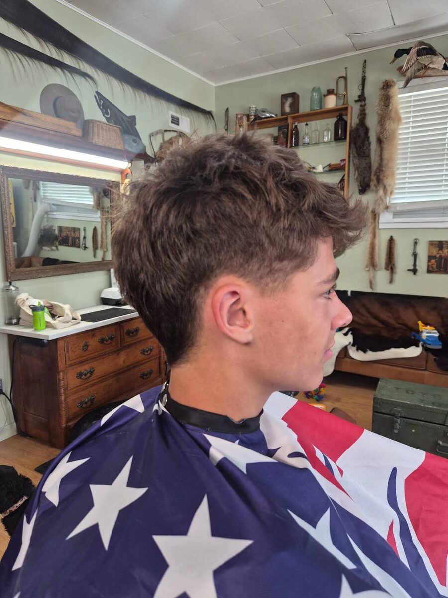 Young man with textured crop haircut in American flag cape