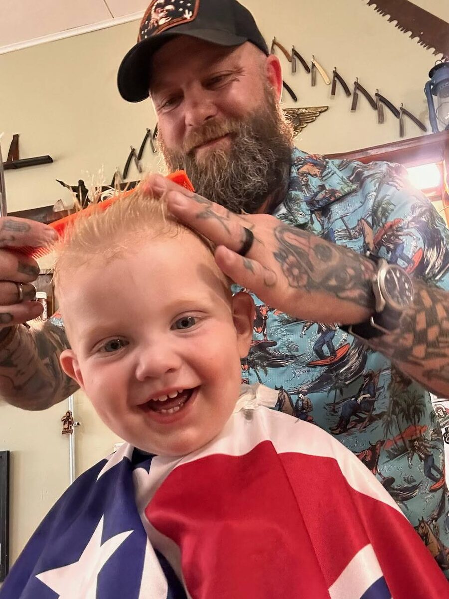 Toddler with fresh haircut smiling while getting styled